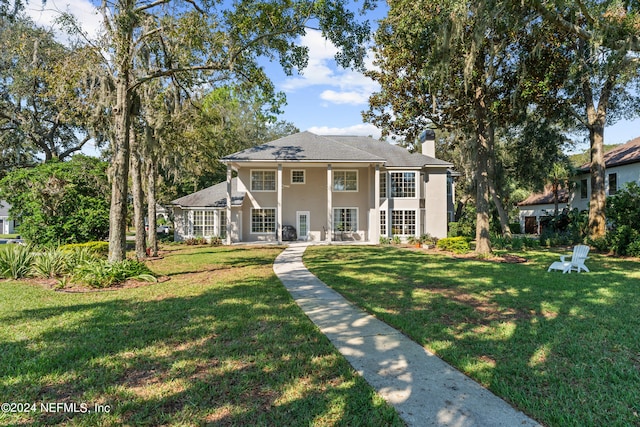 13601 Emerald Cove Ct, Jacksonville, FL 32225 - neoclassical home with a front lawn, a chimney, and stucco siding