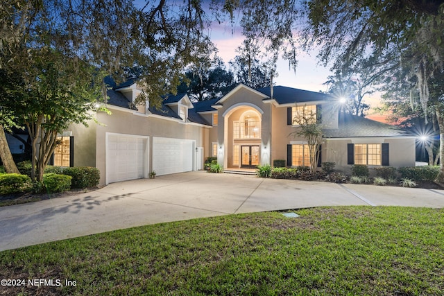 13601 Emerald Cove Ct, Jacksonville, FL 32225 - traditional-style house with french doors, concrete driveway, an attached garage, a yard, and stucco siding