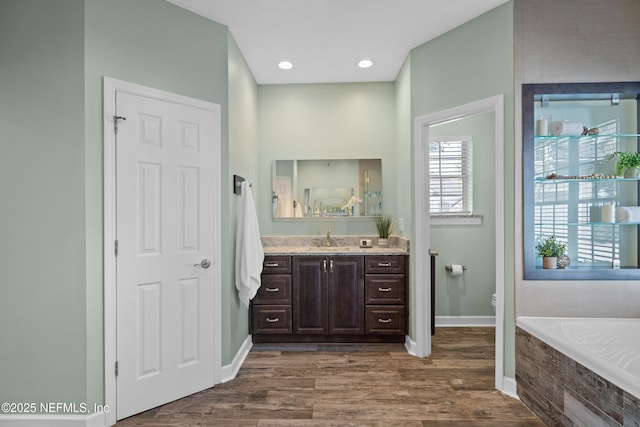 13601 Emerald Cove Ct, Jacksonville, FL 32225 - full bath featuring wood finished floors, toilet, vanity, baseboards, and tiled tub