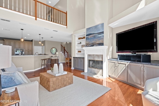 13601 Emerald Cove Ct, Jacksonville, FL 32225 - living room featuring light wood-type flooring, a towering ceiling, stairs, and visible vents