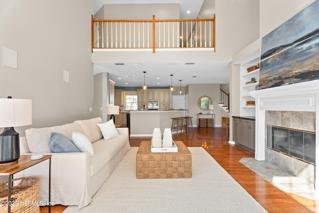 13601 Emerald Cove Ct, Jacksonville, FL 32225 - living area featuring wood finished floors, stairs, built in features, a fireplace, and a high ceiling