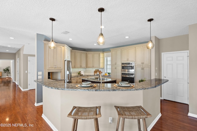 13601 Emerald Cove Ct, Jacksonville, FL 32225 - kitchen with stainless steel appliances, visible vents, dark wood-type flooring, and cream cabinets