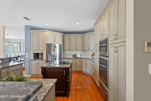 13601 Emerald Cove Ct, Jacksonville, FL 32225 - kitchen featuring wood finished floors, decorative backsplash, a textured ceiling, appliances with stainless steel finishes, and cream cabinets