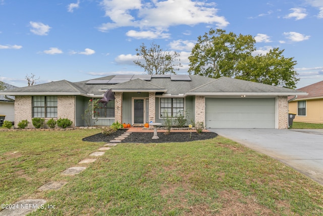 ranch-style home with a front yard, solar panels, and a garage