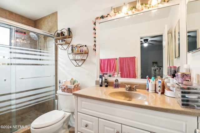 bathroom with toilet, an enclosed shower, vanity, and ceiling fan