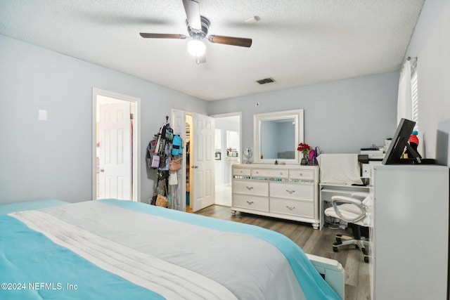 bedroom featuring ceiling fan, a textured ceiling, and dark hardwood / wood-style floors