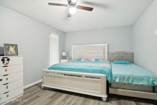 bedroom featuring ceiling fan, a textured ceiling, and hardwood / wood-style floors