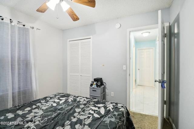 bedroom with a closet, a textured ceiling, carpet, and ceiling fan