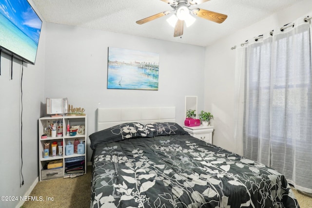 bedroom with ceiling fan, carpet flooring, and a textured ceiling