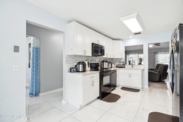 kitchen featuring white cabinetry, black appliances, sink, and decorative backsplash