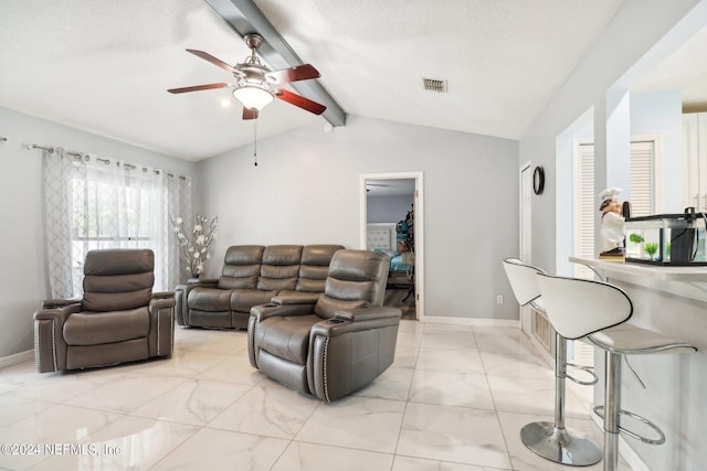 living room with vaulted ceiling with beams, a textured ceiling, and ceiling fan