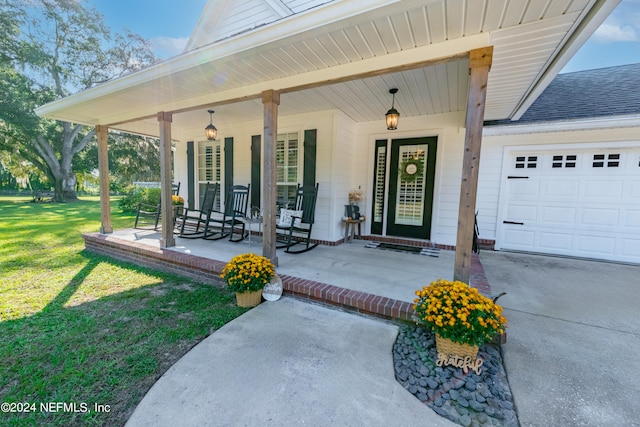 entrance to property with a yard, covered porch, and a garage