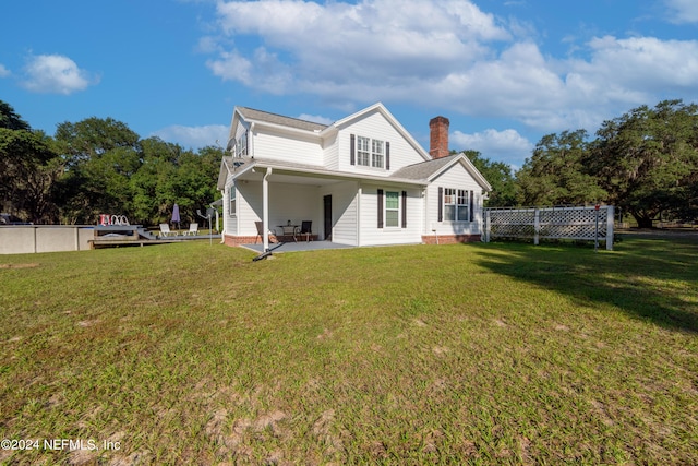 rear view of house featuring a yard and a patio area