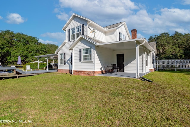 back of property featuring a deck, a yard, and a patio