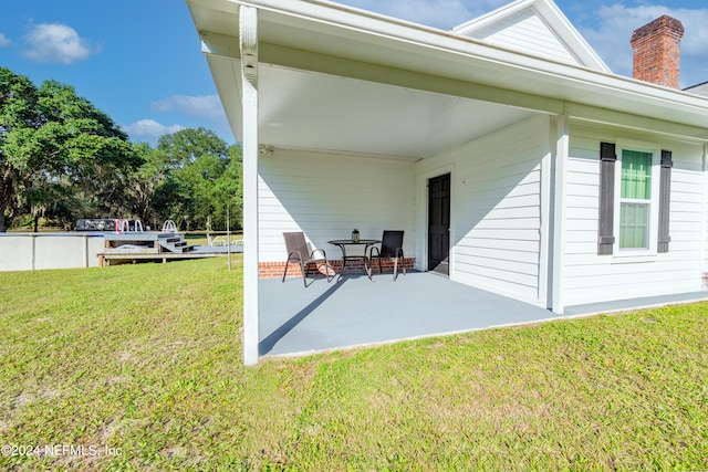 back of property with a patio and a lawn