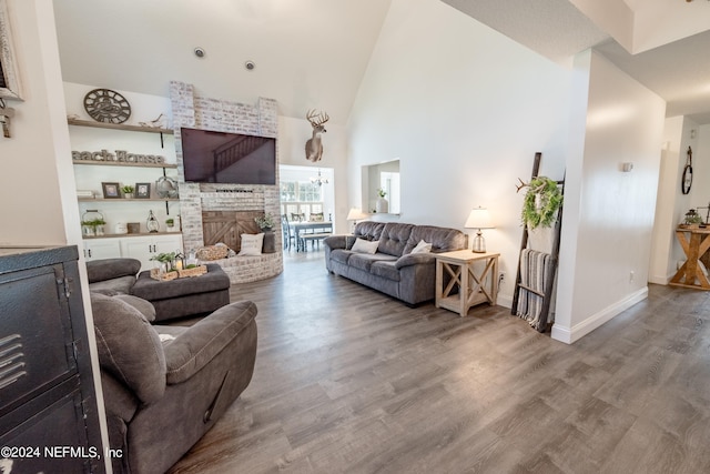 living room featuring high vaulted ceiling, a fireplace, and hardwood / wood-style floors