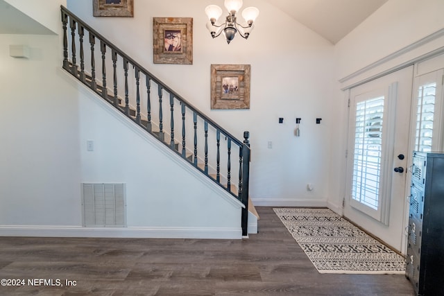 entryway featuring a notable chandelier, lofted ceiling, and dark wood-type flooring