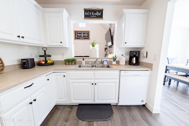 kitchen featuring white dishwasher, hardwood / wood-style flooring, white cabinetry, and sink