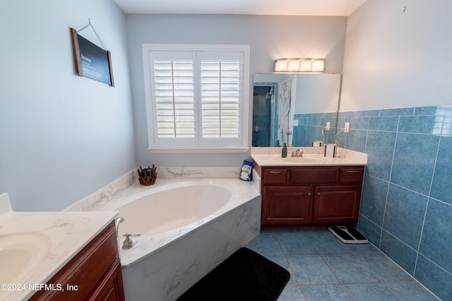 bathroom featuring tile patterned floors, separate shower and tub, vanity, and tile walls