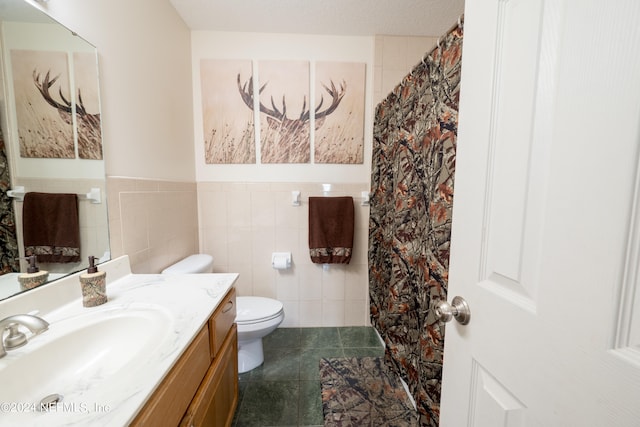 bathroom featuring vanity, tile walls, and toilet