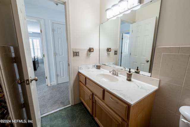 bathroom featuring vanity, tile walls, tile patterned flooring, and toilet