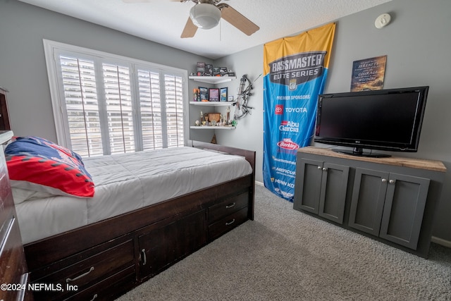 carpeted bedroom with ceiling fan and a textured ceiling