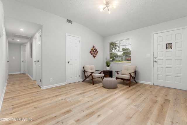 sitting room with a textured ceiling and light wood-type flooring