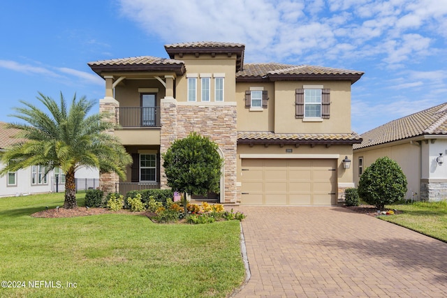 mediterranean / spanish house featuring a front yard, a balcony, and a garage