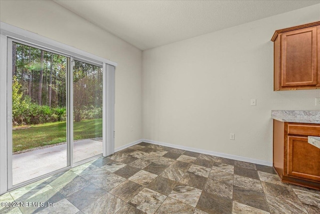 unfurnished dining area featuring a textured ceiling