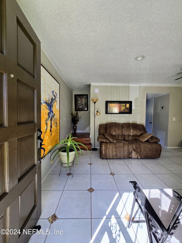 living room featuring light tile patterned flooring, ornamental molding, and a textured ceiling