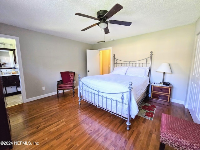 bedroom with ceiling fan, sink, connected bathroom, dark hardwood / wood-style flooring, and a textured ceiling