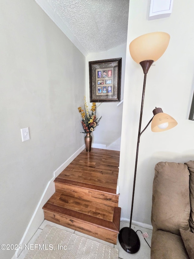 staircase with lofted ceiling and a textured ceiling