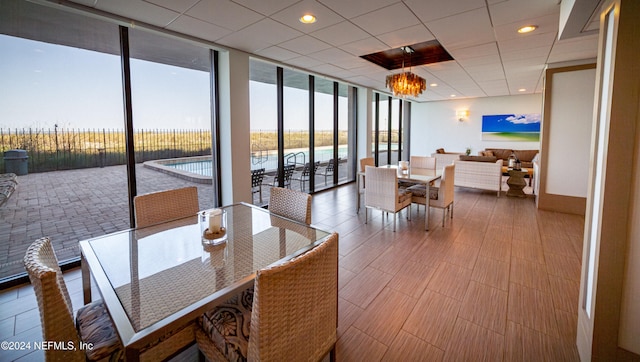 dining space with a water view, expansive windows, a wealth of natural light, and an inviting chandelier