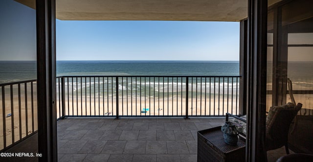 balcony featuring a water view and a view of the beach