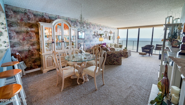 carpeted dining area featuring a wall of windows, a textured ceiling, and a water view