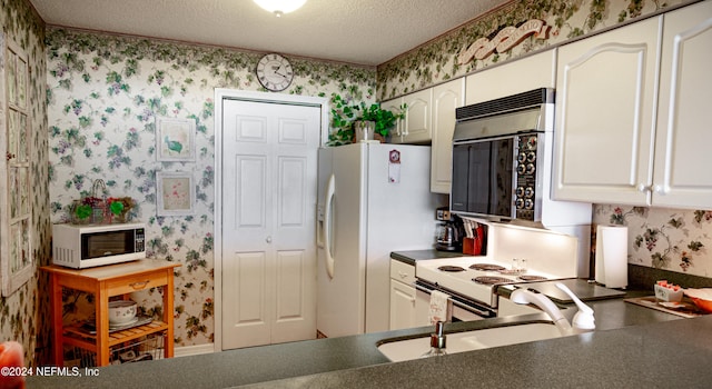 kitchen featuring sink, white cabinets, a textured ceiling, and white appliances