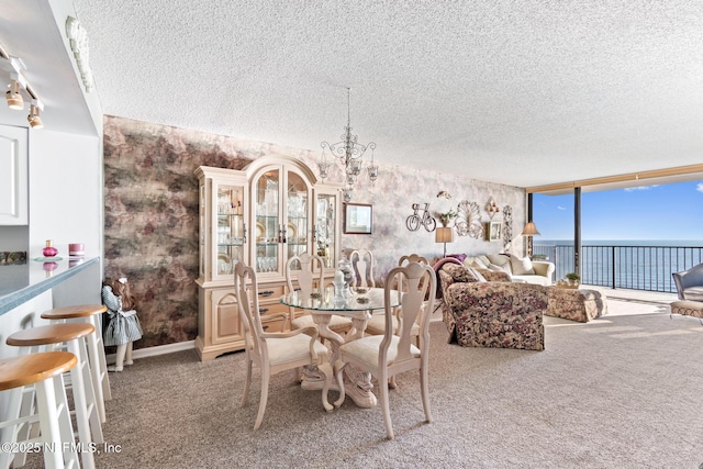1301 1st St S Unit 1202, Jacksonville Beach, FL 32250 - carpeted dining space with expansive windows, wallpapered walls, a water view, a textured ceiling, and a chandelier