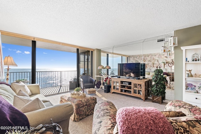 1301 1st St S Unit 1202, Jacksonville Beach, FL 32250 - living area featuring carpet floors, a water view, a textured ceiling, and floor to ceiling windows