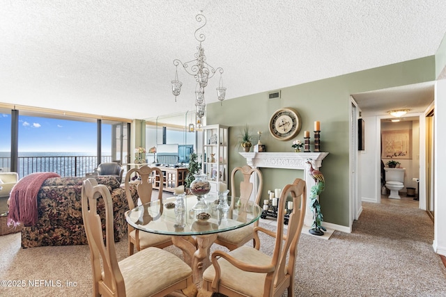 1301 1st St S Unit 1202, Jacksonville Beach, FL 32250 - carpeted dining area with a textured ceiling, a wall of windows, a water view, and baseboards