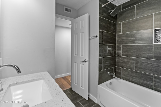 bathroom featuring vanity and tiled shower / bath combo