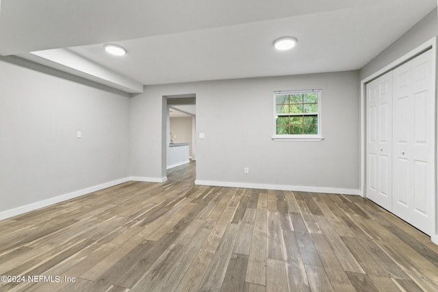 unfurnished bedroom with a closet and hardwood / wood-style flooring