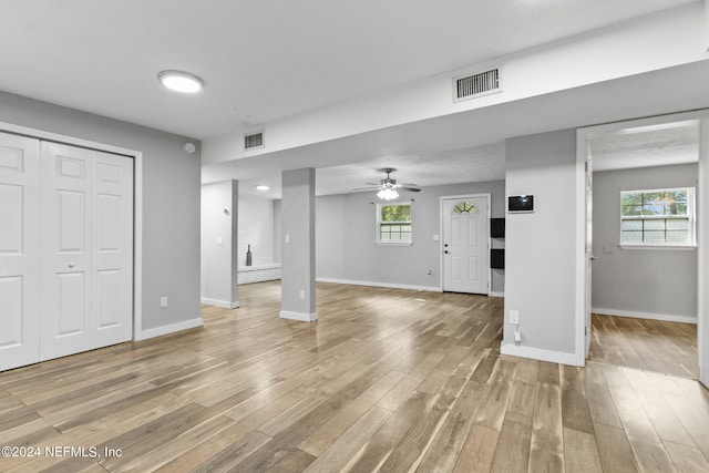 unfurnished living room with ceiling fan, plenty of natural light, and hardwood / wood-style floors