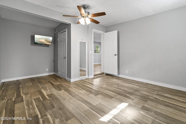 unfurnished bedroom featuring a textured ceiling, dark wood-type flooring, and ceiling fan