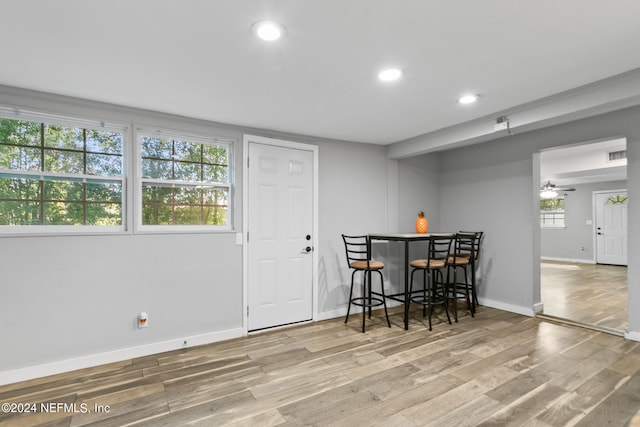 dining space with hardwood / wood-style floors, bar area, and ceiling fan