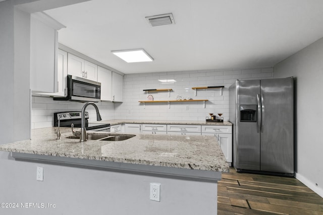 kitchen featuring kitchen peninsula, dark hardwood / wood-style flooring, appliances with stainless steel finishes, white cabinetry, and light stone countertops