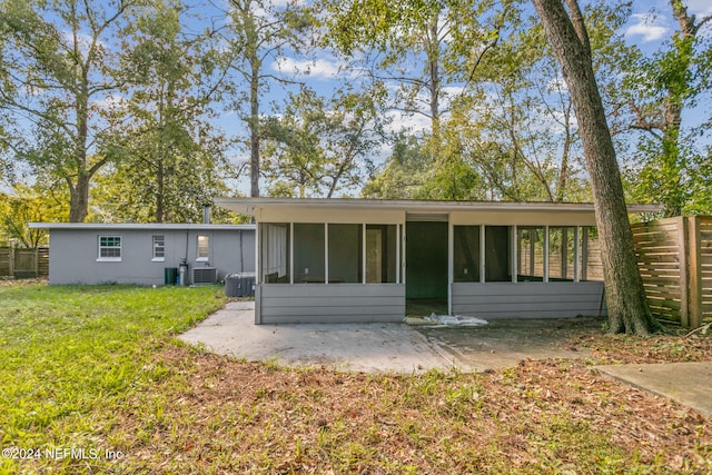 back of house featuring a yard, a sunroom, and a patio area