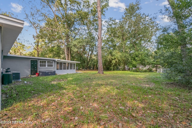 view of yard featuring central AC unit and a sunroom