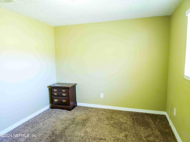 carpeted empty room featuring a textured ceiling