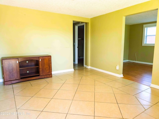 tiled spare room featuring a textured ceiling