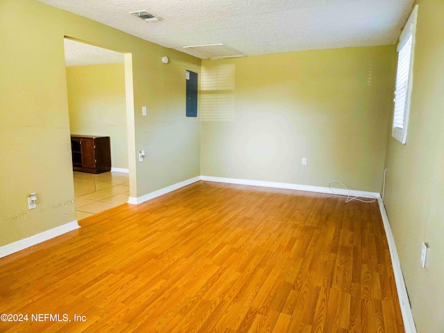 unfurnished room with a textured ceiling and light hardwood / wood-style flooring